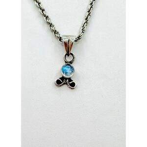 Silver tone rope chain stick figure with blue gemstone pendant necklace